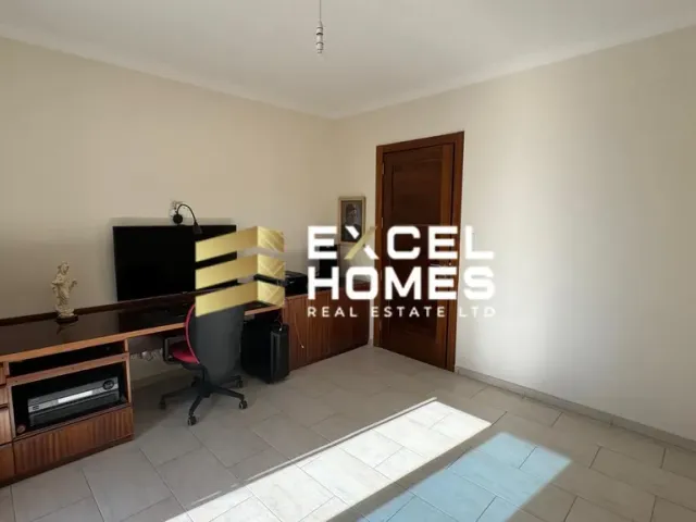 a living room with a tv and a desk