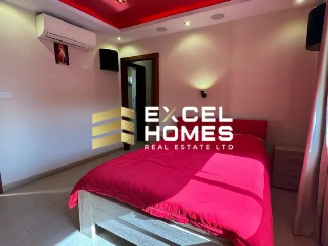 a bed room with a red blanket and a red wall