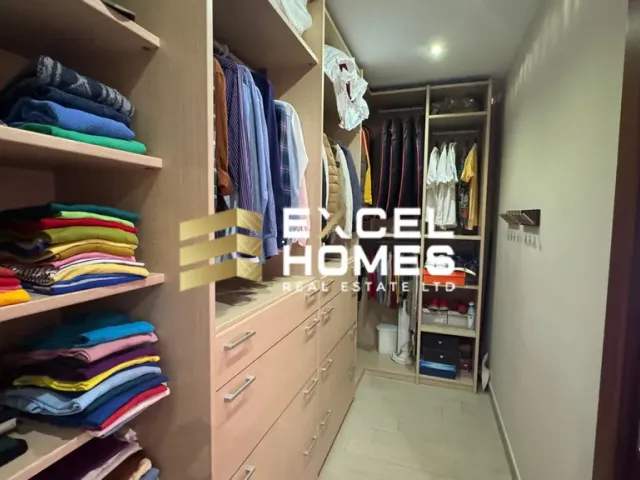 a room with a bed, dresser, and a shelf with books