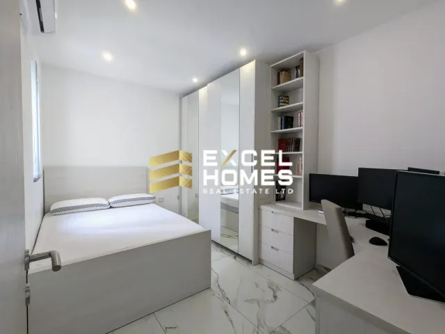a room with a bed, a desk, and a mirror 