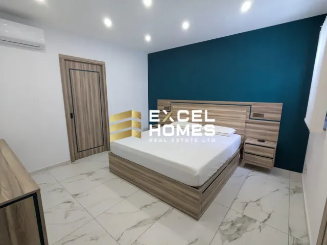a bedroom with a bed, a dresser, and a lamp 