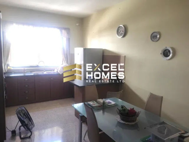 a kitchen with a table and chairs and a clock