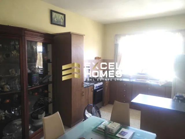 a kitchen with a table and chairs and a refrigerator