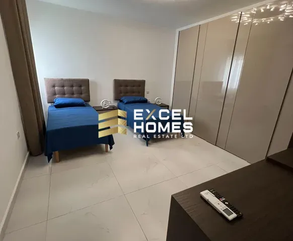 a bedroom with a bed, desk, and a television