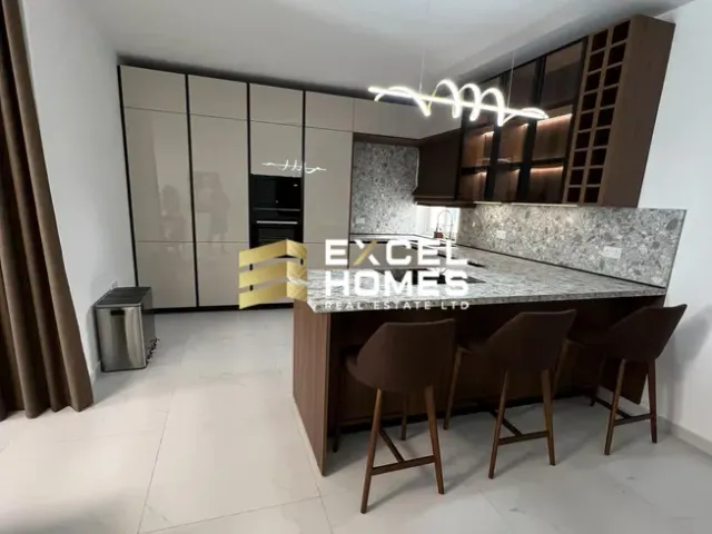 a kitchen with a sink, counter, and a refrigerator