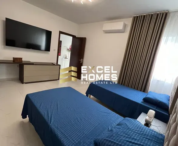 a hotel room with a bed, television and a desk