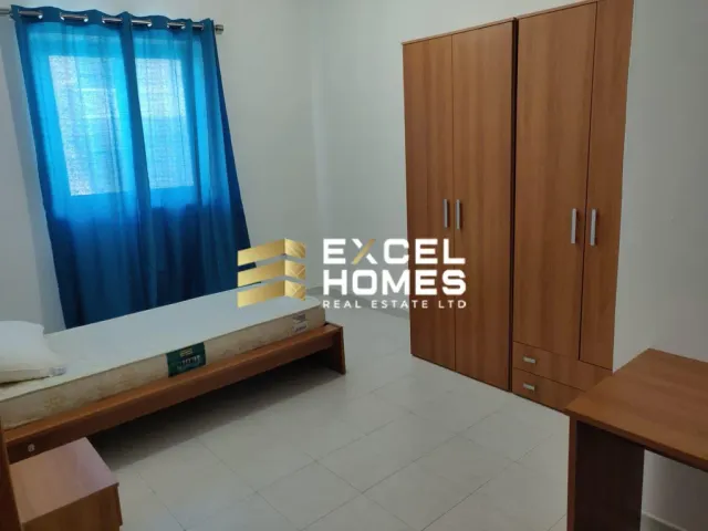 a bedroom with a bed, desk, and a window