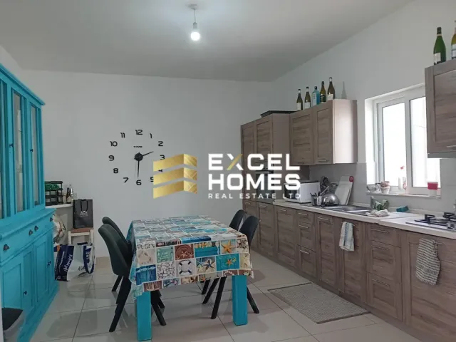 a kitchen with a table and chairs and a refrigerator