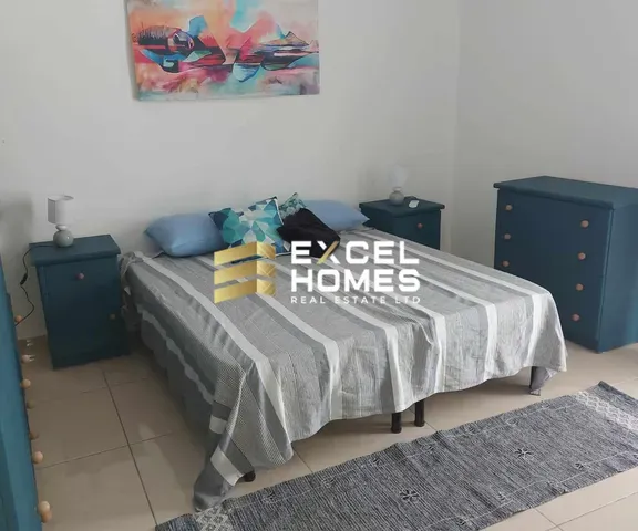 a bed with a blanket and a lamp on it