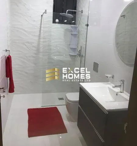 a bathroom with a shower, toilet, sink and a mirror 