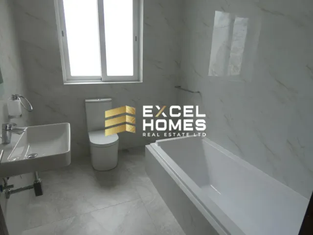 a bathroom with a toilet, sink, tub and window 