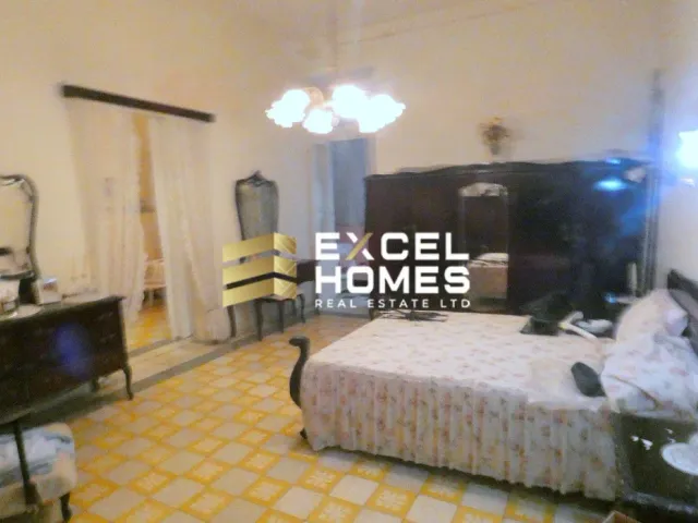 a bedroom with a bed, television, and a lamp 