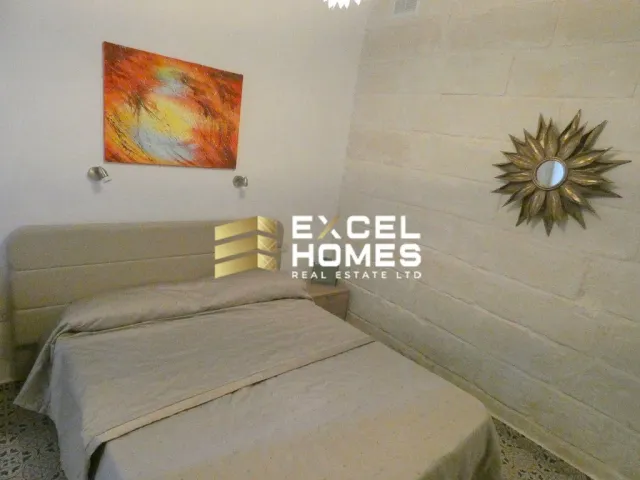 a bedroom with a bed, a lamp, and a wall