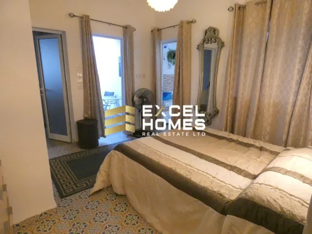 a bedroom with a bed, mirror and a window