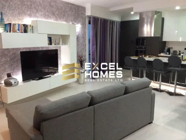 a living room with a couch, coffee table and television