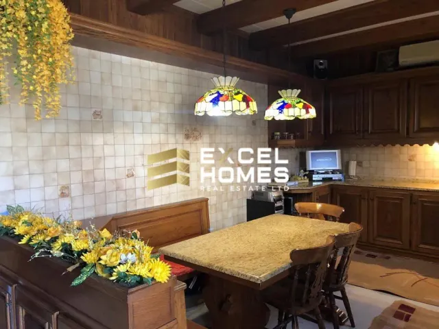 a kitchen with a table and chairs and a vase of flowers