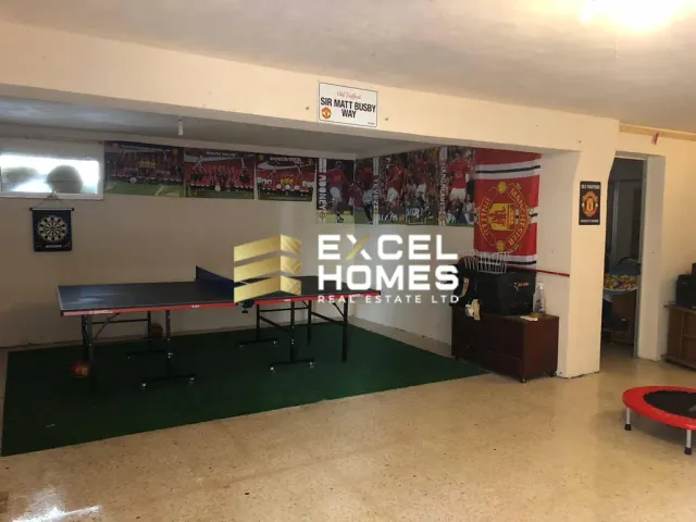 a room with a table and chairs and a wall with a sign