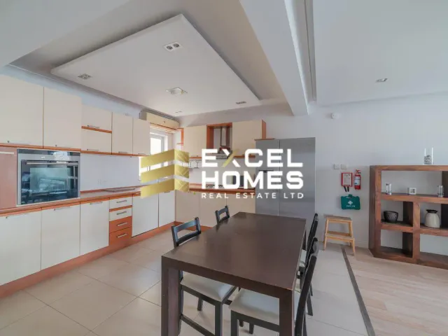 a kitchen with a table and chairs and a refrigerator