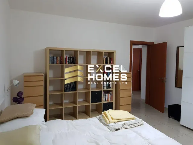 a bedroom with a bed, desk, and bookshelf