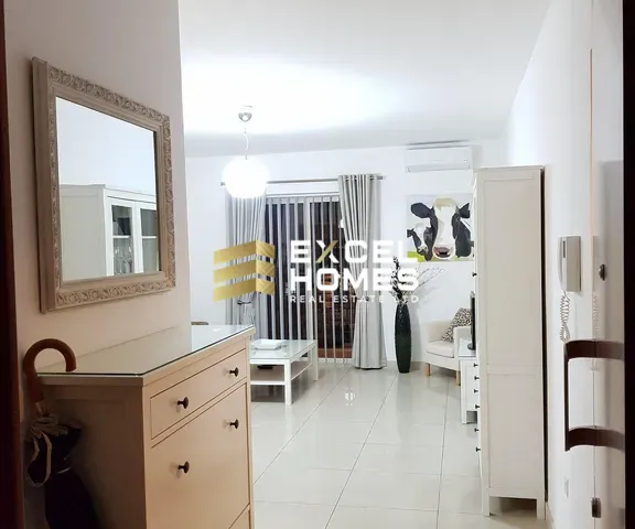 a room with a white wall and a white bed