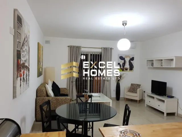 a living room with a couch, table, television and a lamp