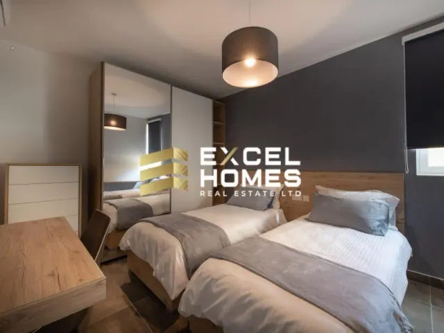 a bedroom with a bed, desk, and a lamp