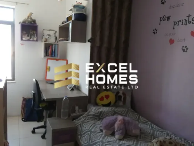 a bedroom with a bed, desk, and a painting on the wall