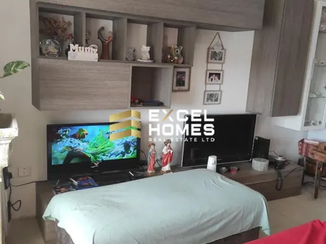 a bedroom with a bed, desk, and television