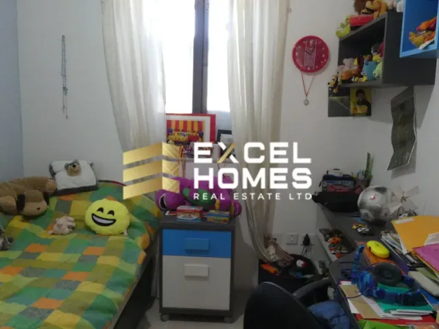 a bedroom with a bed, desk, and a computer