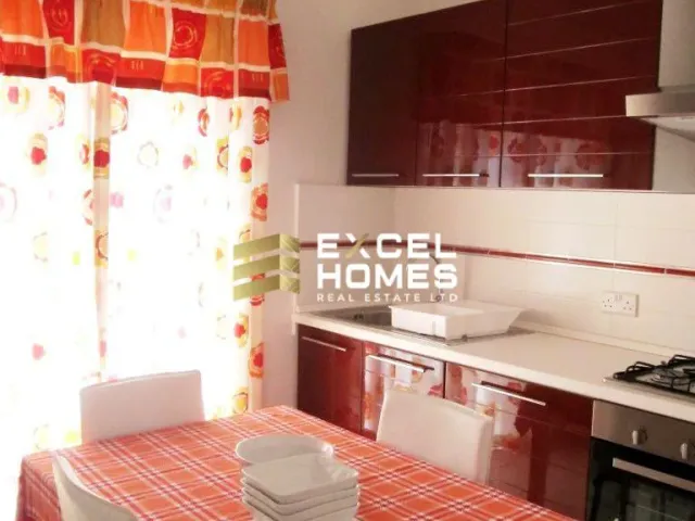 a small kitchen with a white bed and a white stove