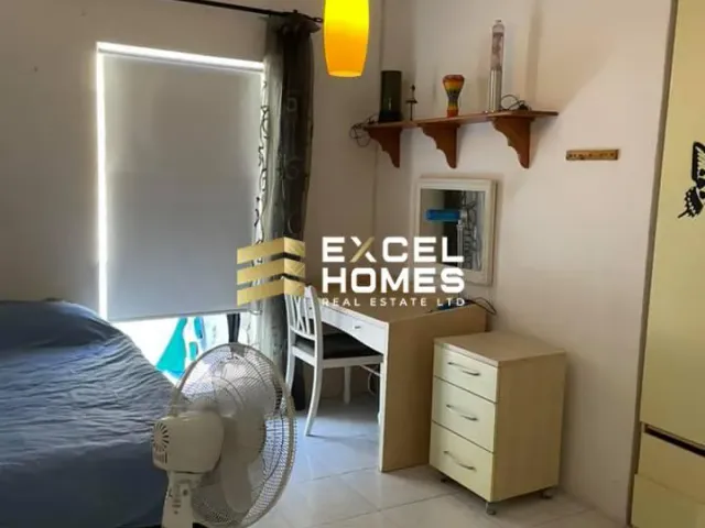a bedroom with a bed, desk, and a lamp 