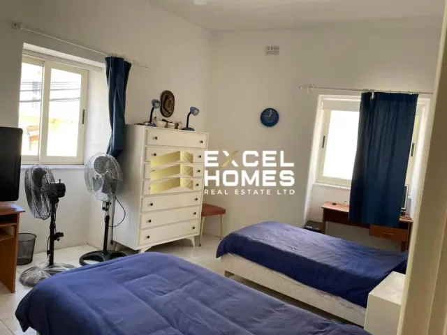 a bedroom with a bed, desk, and a window 