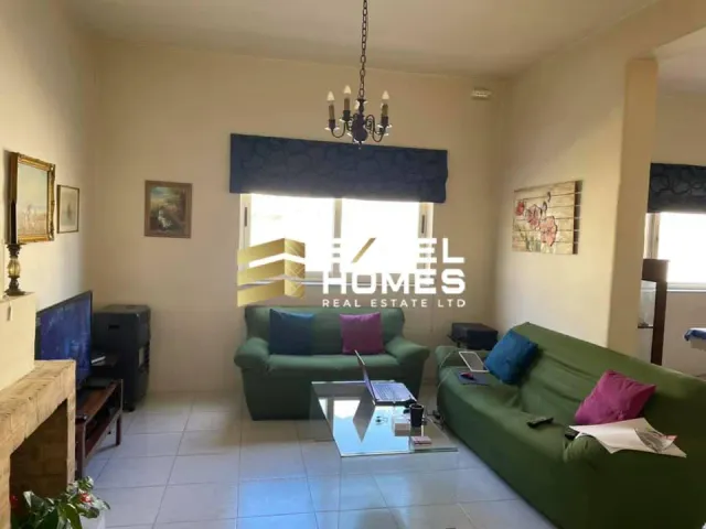 a living room with a couch, coffee table and a window 