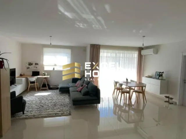 a living room with a couch, coffee table and a tv