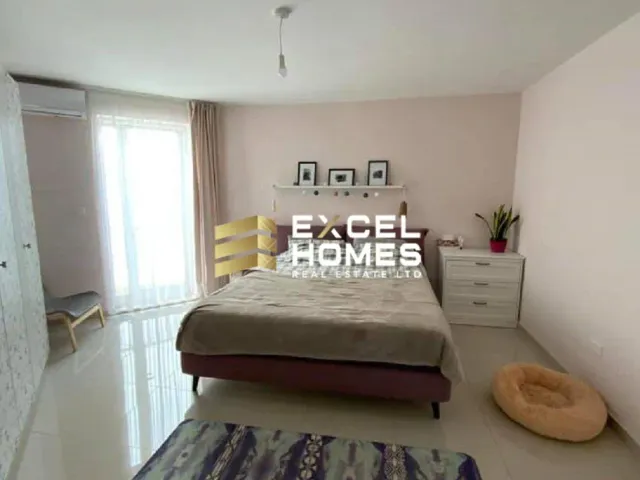 a bedroom with a bed, a desk and a painting