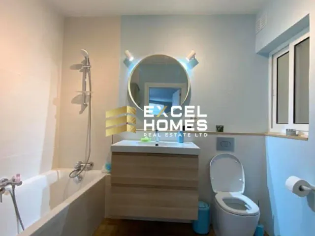 a bathroom with a toilet, sink, and mirror
