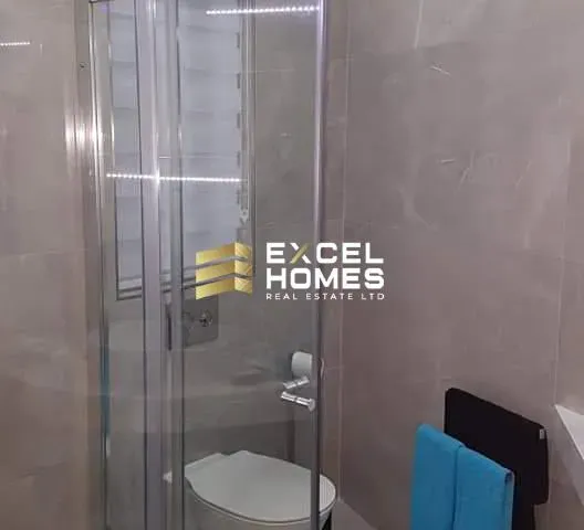 a shower stall with a glass door and a toilet