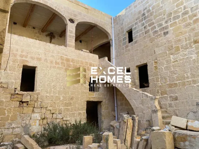 a building with a stone wall and a clock on it