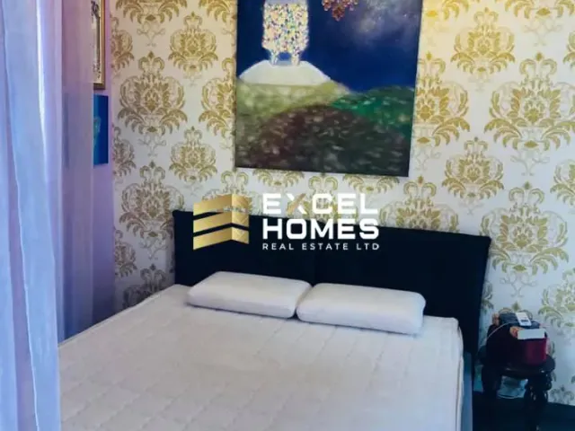 a bed with a white bedspread and a white wall 
