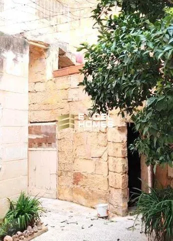 a brick building with a tree and a street sign