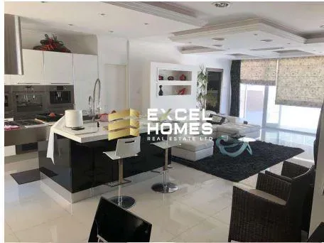 a living room with a large window and a large kitchen 