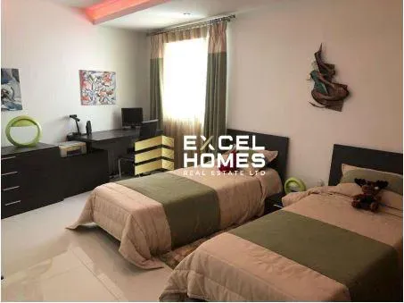 a bedroom with a bed, desk, and a lamp 