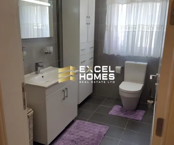 a bathroom with a toilet, sink, and mirror