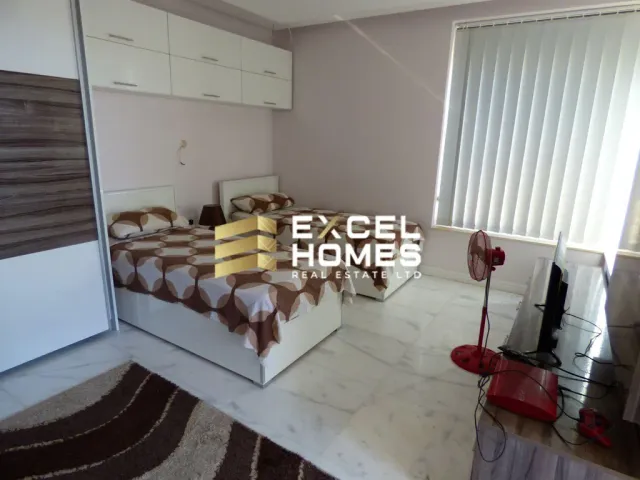 a bedroom with a bed, a table and a window