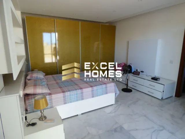 a bedroom with a bed, desk, and a lamp