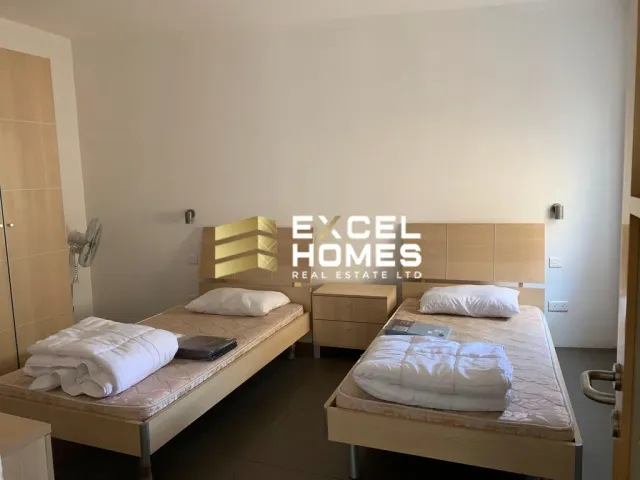 a bed room with two beds and a desk 