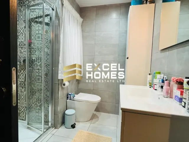 a bathroom with a shower, toilet, sink and a mirror