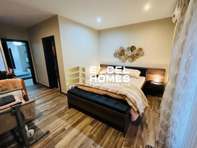 a bedroom with a bed, chair, and a tv