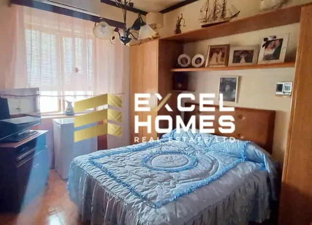 a bedroom with a bed, desk, and a bedspread 
