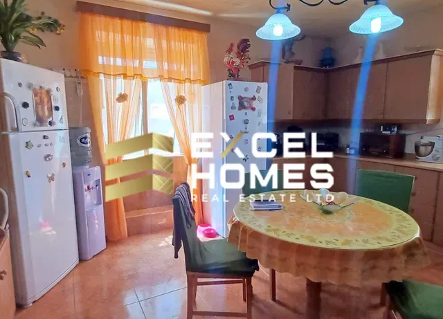 a kitchen with a table, chairs, and a refrigerator 